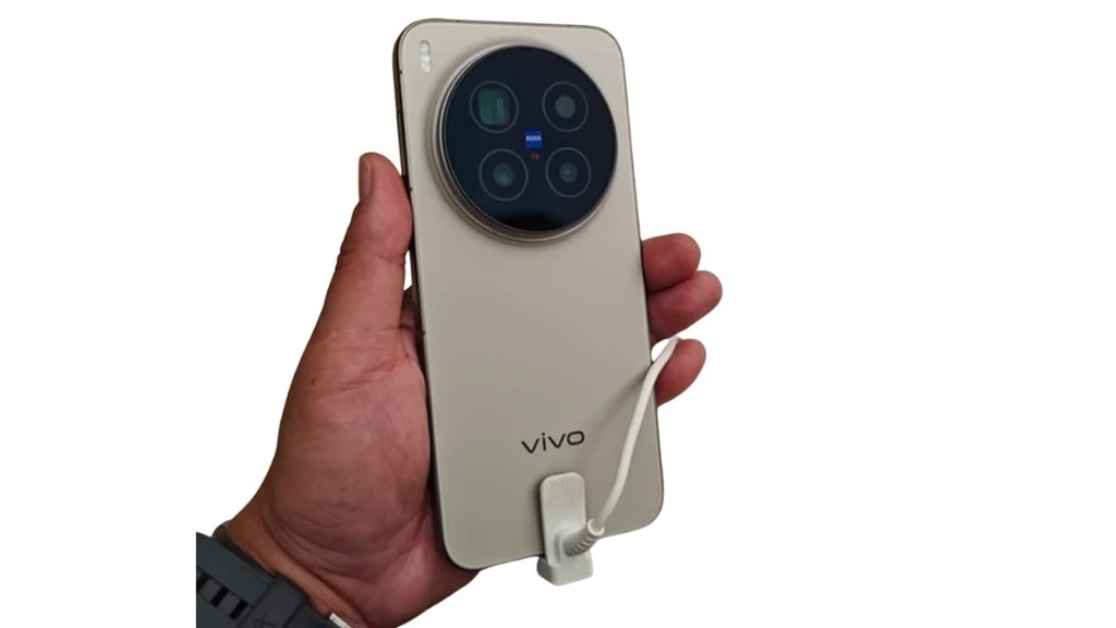 Vivo X300e के स्पेसिफिकेशन फिर हुए लीक, 7100mAh बैटरी, Snapdragon 8 Gen 5 और Zeiss कैमरा मिलने की उम्मीद 1 # Vivo X300e के स्पेसिफिकेशन फिर हुए लीक, 7100mAh बैटरी, Snapdragon 8 Gen 5 और Zeiss कैमरा मिलने की उम्मीद Vivo अपने फ्लैगशिप स्मार्टफोन पोर्टफोलियो का विस्तार करने की तैयारी कर रहा है। लॉन्च से पहले **Vivo X300e** के स्पेसिफिकेशन एक बार फिर ऑनलाइन लीक हुए हैं। नई रिपोर्ट के मुताबिक, यह स्मार्टफोन बड़ी बैटरी, दमदार प्रोसेसर और Zeiss कैमरा सिस्टम के साथ बाजार में एंट्री कर सकता है। हालांकि, कंपनी ने अभी तक इस डिवाइस की लॉन्च डेट या फीचर्स की आधिकारिक पुष्टि नहीं की है। लीक के अनुसार, Vivo X300e को प्रीमियम सेगमेंट के उन ग्राहकों को ध्यान में रखकर तैयार किया गया है, जो बेहतर कैमरा, लंबी बैटरी लाइफ और फ्लैगशिप लेवल की परफॉर्मेंस चाहते हैं। ## 7100mAh बैटरी और 90W फास्ट चार्जिंग मिल सकती है रिपोर्ट्स के मुताबिक Vivo X300e में **7015mAh से 7100mAh** क्षमता की बड़ी बैटरी दी जा सकती है। इसके साथ **90W वायर्ड फास्ट चार्जिंग** का सपोर्ट मिलने की भी संभावना है। अगर यह जानकारी सही साबित होती है, तो यह स्मार्टफोन मौजूदा फ्लैगशिप फोनों की तुलना में काफी बड़ी बैटरी के साथ आएगा। माना जा रहा है कि यह लंबे समय तक बैकअप देने वाले प्रीमियम स्मार्टफोनों में शामिल हो सकता है। ## Snapdragon 8 Gen 5 प्रोसेसर से मिलेगी फ्लैगशिप परफॉर्मेंस Vivo X300e में **Qualcomm Snapdragon 8 Gen 5** चिपसेट दिए जाने की उम्मीद है। यह प्रोसेसर हाई-एंड गेमिंग, मल्टीटास्किंग और AI आधारित फीचर्स के लिए बेहतर प्रदर्शन देने में सक्षम माना जा रहा है। फोन में **16GB तक RAM** और **1TB तक इंटरनल स्टोरेज** मिलने की भी संभावना जताई गई है। ## Zeiss कैमरा के साथ ट्रिपल रियर कैमरा सेटअप फोटोग्राफी के लिए Vivo X300e में **50MP का प्राइमरी कैमरा**, **50MP पेरिस्कोप टेलीफोटो कैमरा** और **8MP अल्ट्रा-वाइड कैमरा** दिया जा सकता है। वहीं सेल्फी और वीडियो कॉलिंग के लिए **50MP फ्रंट कैमरा** मिलने की उम्मीद है। फोन में Vivo की फ्लैगशिप X-सीरीज की तरह **Zeiss Imaging Technology** का सपोर्ट भी देखने को मिल सकता है, जिससे बेहतर पोर्ट्रेट और लो-लाइट फोटोग्राफी का अनुभव मिलने की संभावना है। ## 1.5K OLED डिस्प्ले और नया डिजाइन लीक रिपोर्ट के अनुसार Vivo X300e में **6.59 इंच का 1.5K OLED डिस्प्ले** दिया जा सकता है। फोन का डिजाइन अन्य X300 सीरीज मॉडल्स से थोड़ा अलग हो सकता है। इसमें गोल कैमरा मॉड्यूल की जगह **स्क्वायर कैमरा आइलैंड** देखने को मिल सकता है। बताया जा रहा है कि फोन की मोटाई केवल **7.99mm** होगी, जबकि इसका वजन करीब **203 ग्राम** रहेगा। ## Vivo X300e के संभावित स्पेसिफिकेशन | फीचर | संभावित जानकारी | | ----------- | ----------------------------------------- | | डिस्प्ले | 6.59-इंच 1.5K OLED | | प्रोसेसर | Qualcomm Snapdragon 8 Gen 5 | | RAM | 16GB तक | | स्टोरेज | 1TB तक | | रियर कैमरा | 50MP + 50MP Periscope + 8MP | | फ्रंट कैमरा | 50MP | | बैटरी | 7015mAh–7100mAh | | चार्जिंग | 90W फास्ट चार्जिंग | | डिजाइन | 7.99mm स्लिम बॉडी, स्क्वायर कैमरा मॉड्यूल | ## लॉन्च को लेकर क्या है जानकारी? रिपोर्ट्स के अनुसार Vivo X300e को सबसे पहले चीन में लॉन्च किया जा सकता है। इससे पहले यह डिवाइस IMEI डेटाबेस में भी देखा जा चुका है, जिसके बाद अब इसके विस्तृत स्पेसिफिकेशन सामने आए हैं। हालांकि, कंपनी ने अभी तक इसकी लॉन्च तारीख और कीमत का खुलासा नहीं किया है। चूंकि यह सभी जानकारियां लीक रिपोर्ट्स पर आधारित हैं, इसलिए आधिकारिक लॉन्च के समय फोन के फीचर्स, कीमत और स्पेसिफिकेशन में बदलाव संभव है। ऐसे में ग्राहकों को अंतिम जानकारी के लिए Vivo की आधिकारिक घोषणा का इंतजार करना चाहिए।